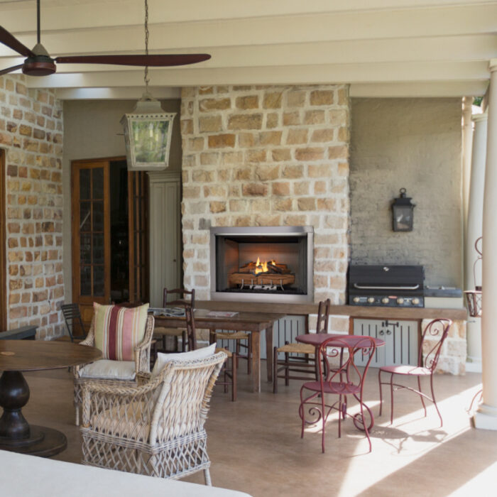Luxury home showcase patio with stone wall and ceiling fans